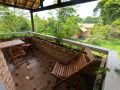 Varanda com mesa e vista para o pátio das mangueiras